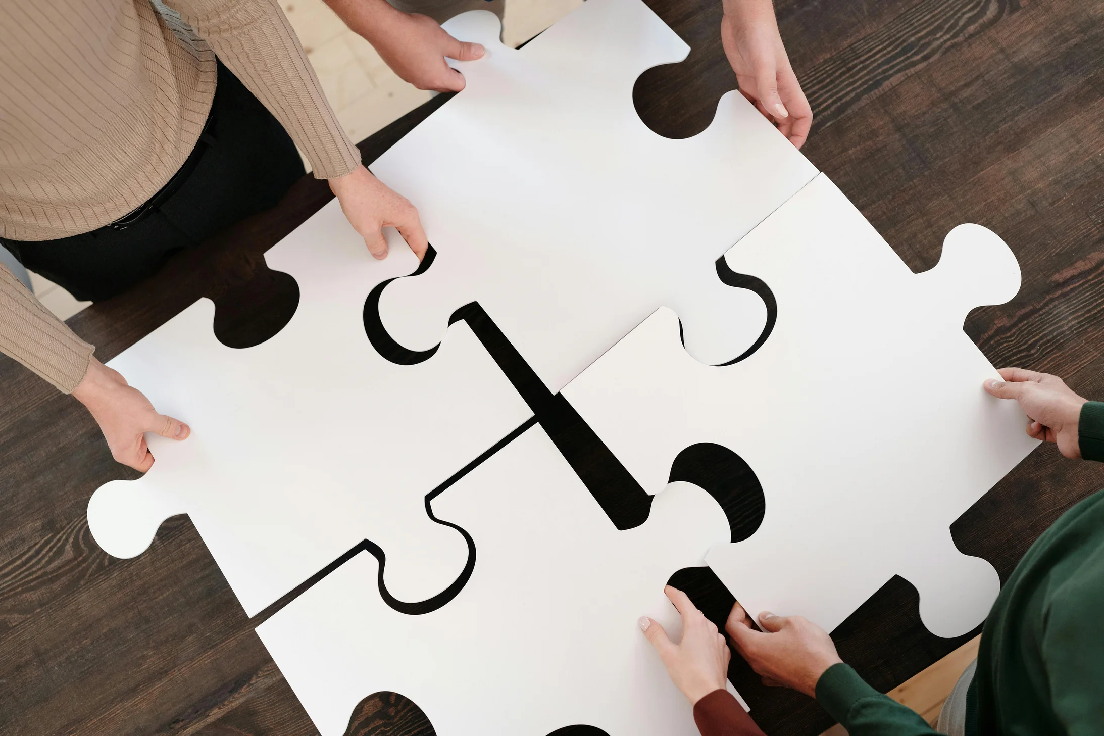 Close up photo of people holding puzzle pieces