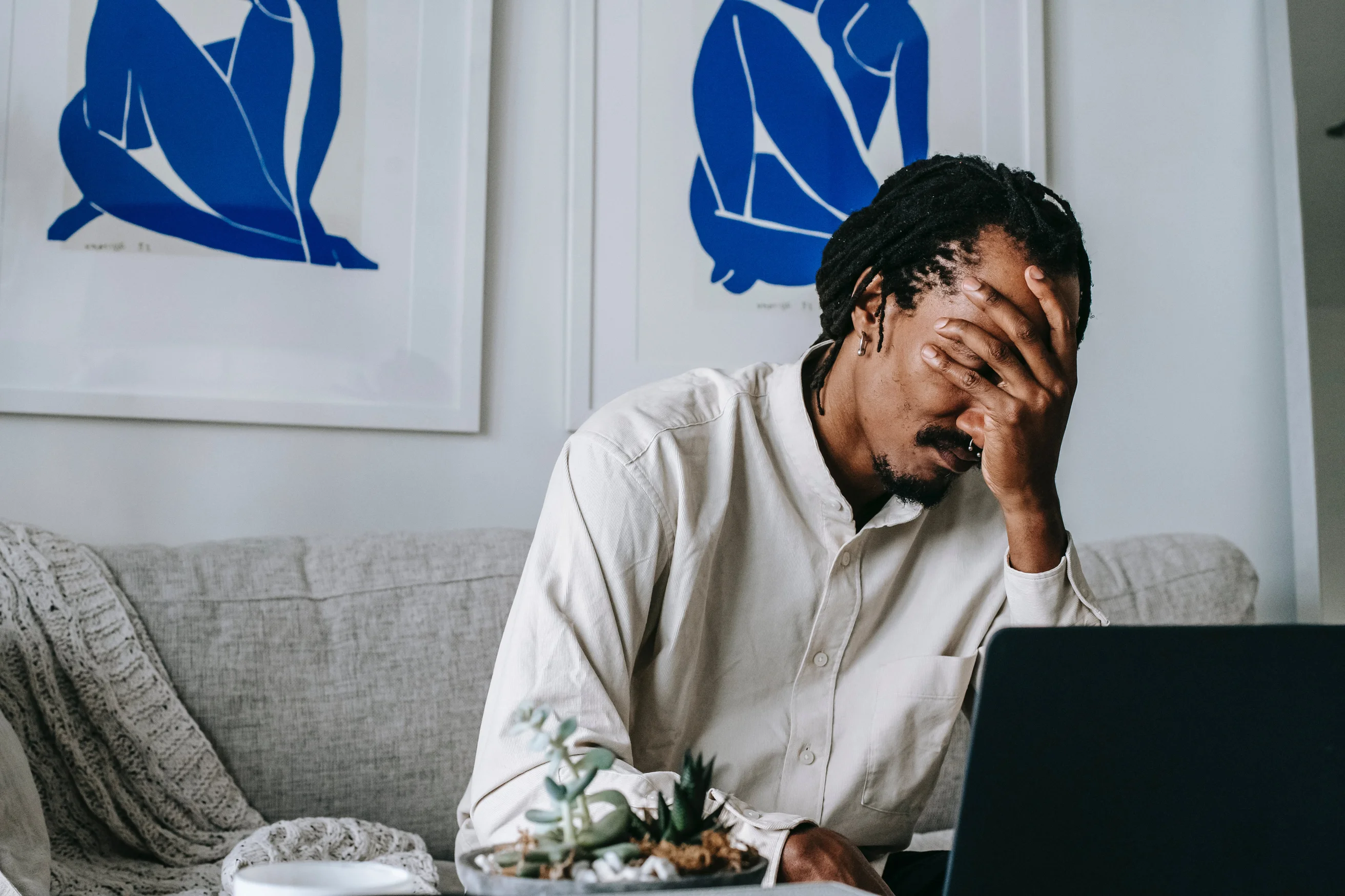 Monsieur qui se tient la tête devant l'ordinateur