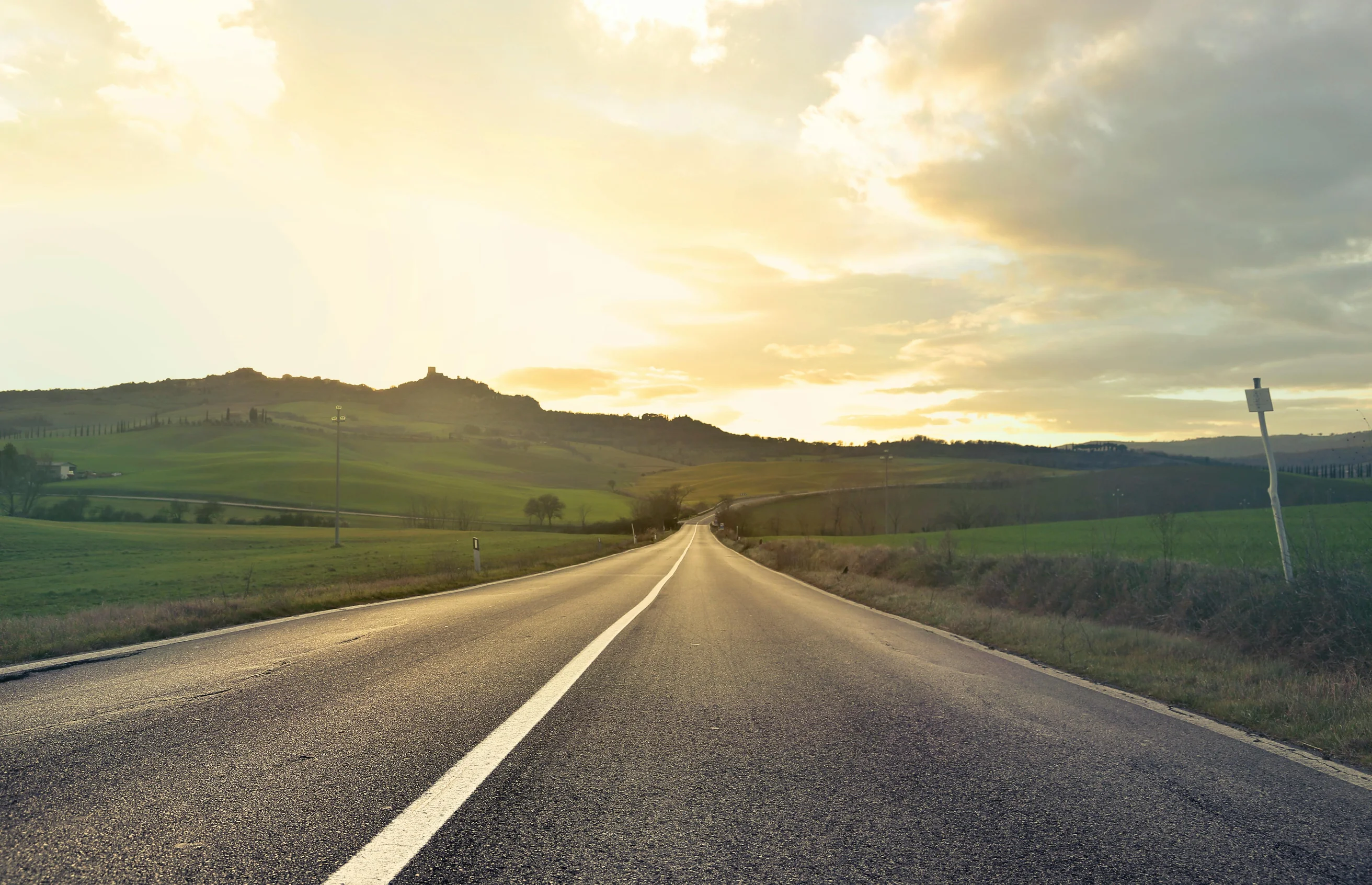 Beautiful empty road in Tuscany, Italy at sunset. Capturing the serene rural landscape and rolling hills.