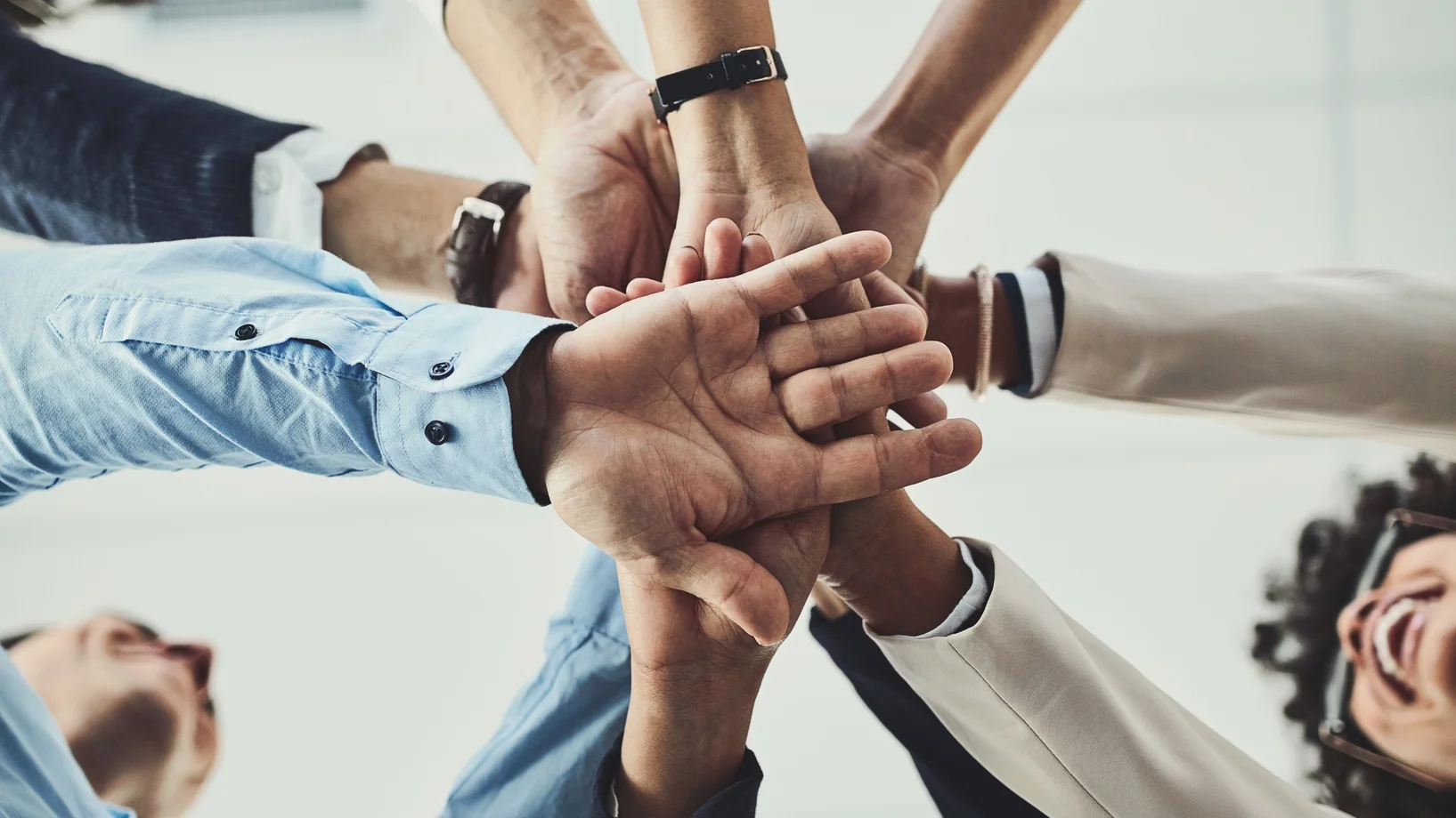 Un groupe de personnes qui se serrent les mains représentant le travail en groupe