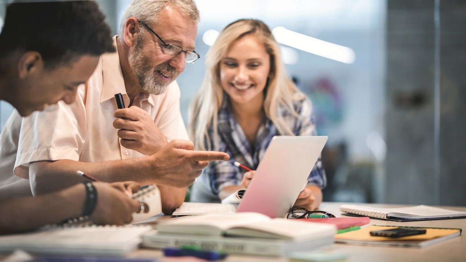 Junger und älterer Herr und blonde Frau am Lernen