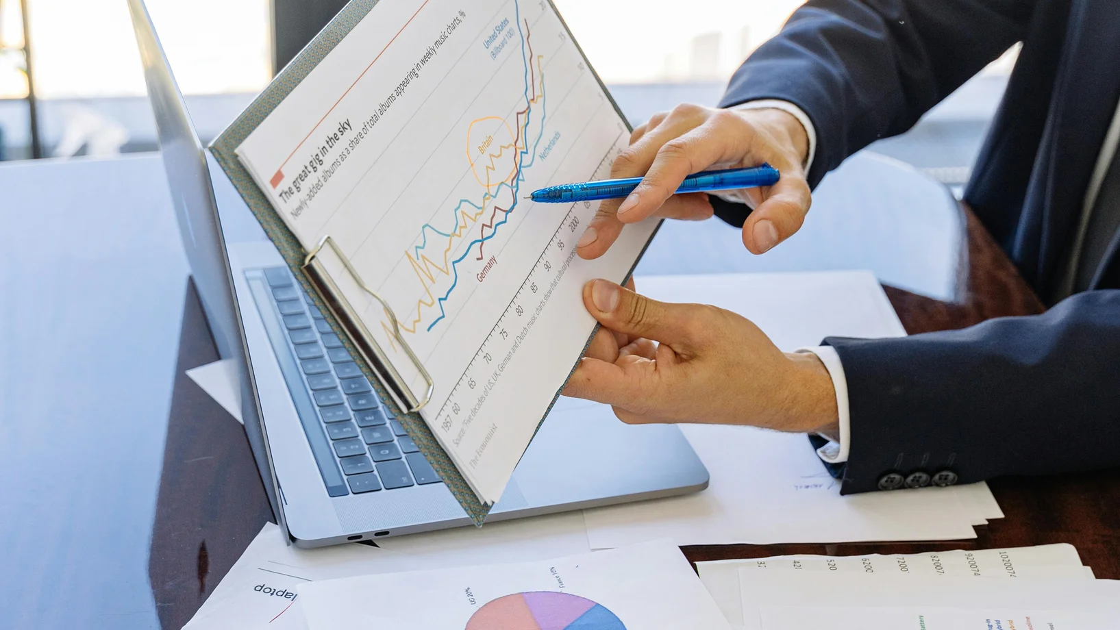 Business professionals discussing financial graphs and charts in an office setting.