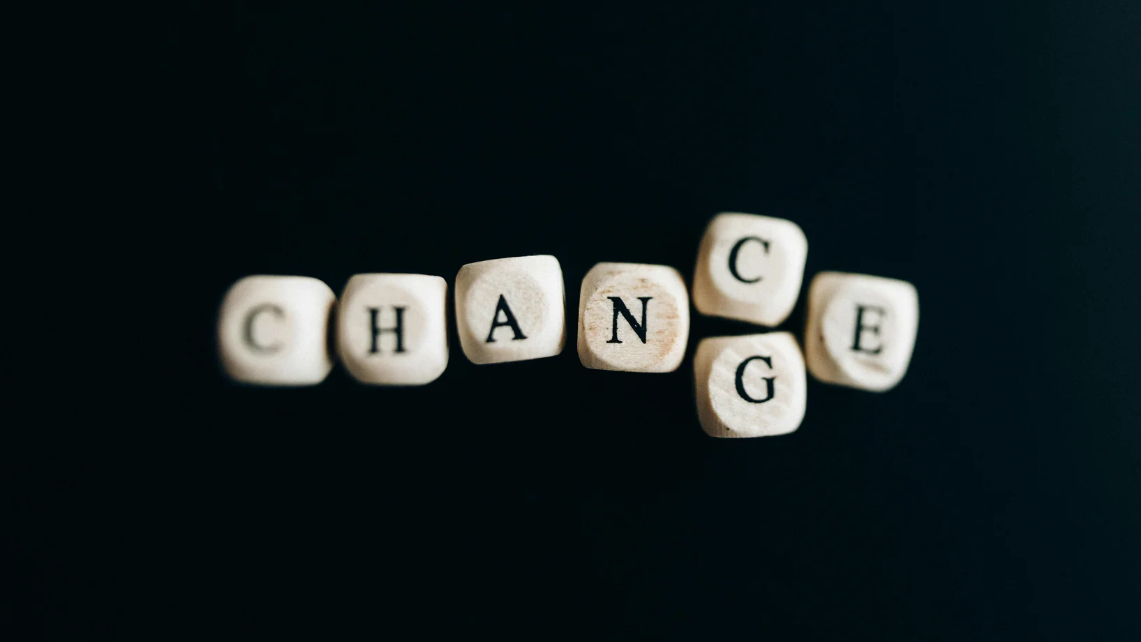 Letter dice forming the word 'Change' on a dark background, symbolizing transformation and opportunity.