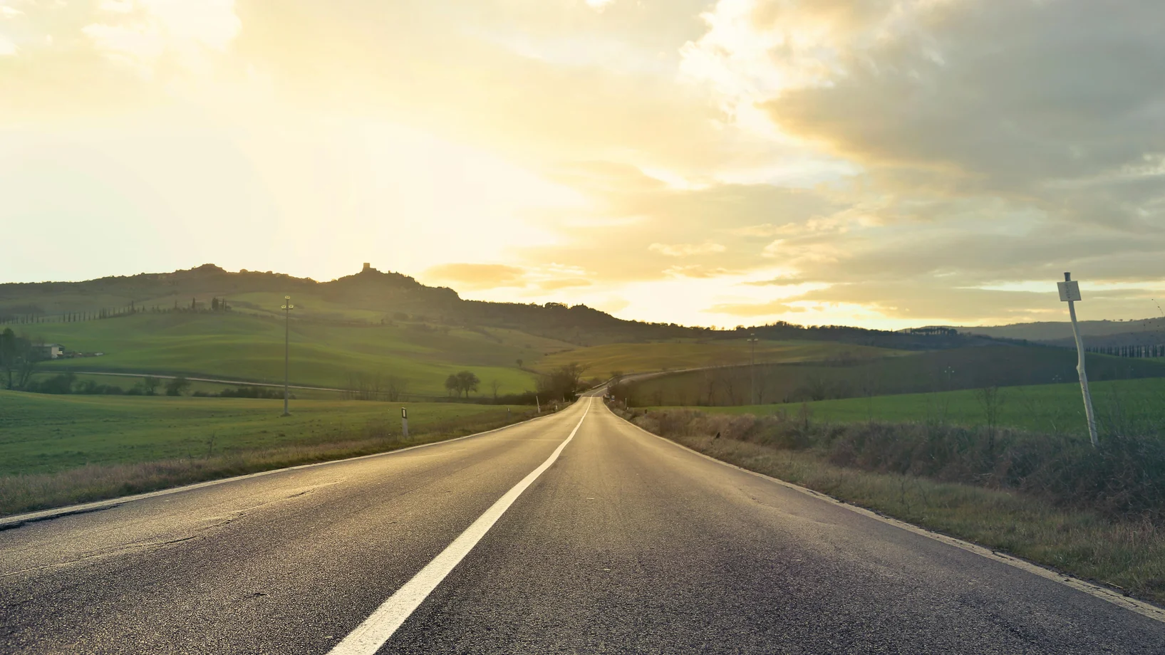 Beautiful empty road in Tuscany, Italy at sunset. Capturing the serene rural landscape and rolling hills.